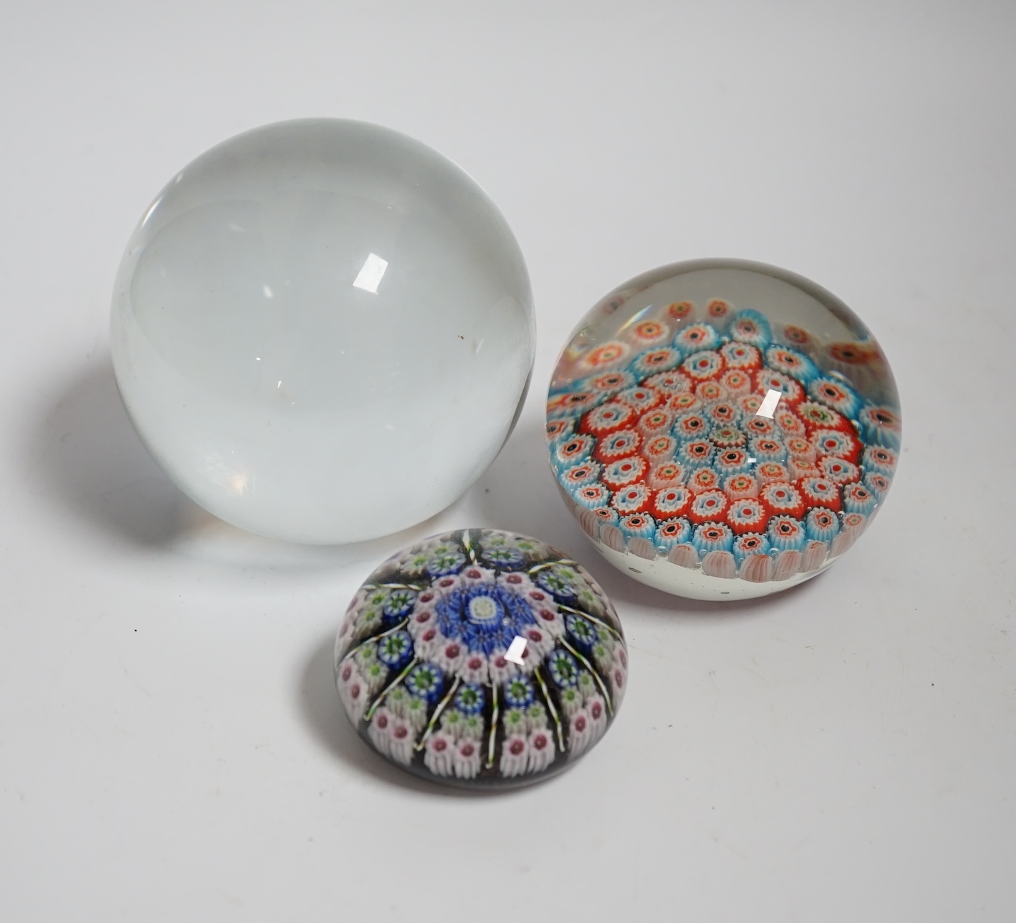 Two millefiori paperweights and a glass ball, largest 10cm in diameter